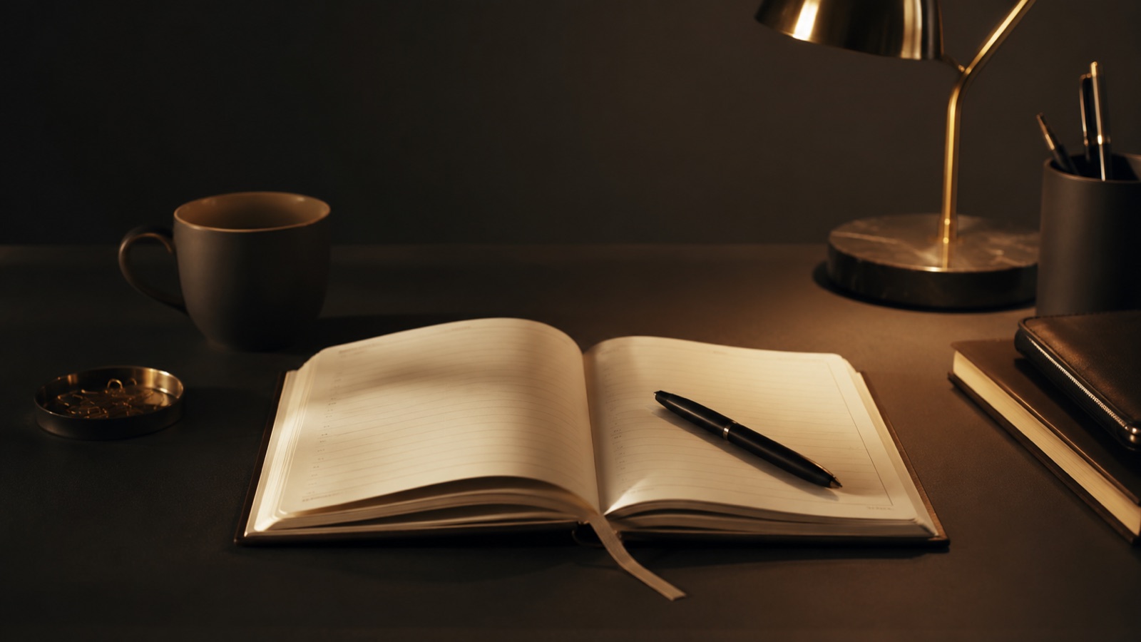 A calm warm-lit desk with a single planner open, showing a steady simple schedule instead of a crammed one